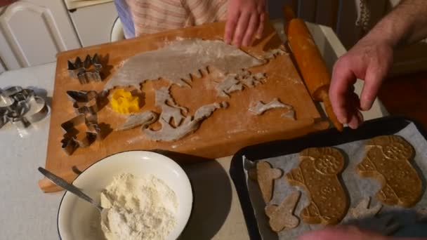 Pareja está cortando galletas en forma de animal hacia fuera masa pastelería cuidadosamente ponerlos a una bandeja de hornear familia está haciendo galletas Ram en forma de galletas Cocina — Vídeos de Stock