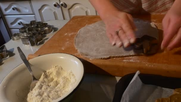 Frau knetet Teig und schneidet Engelskekse, indem sie sie vorsichtig auf ein Backblech legt Familie macht Kekse rammförmige Kekse — Stockvideo