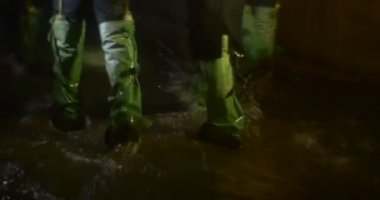 İnsanların çoğu Gumboots su hattı bacaklarda yağmurlama mağara yaktı lamba grup insan tarafından bir yeraltı Kiev'e mağara gezi keşfetmek yürüyor