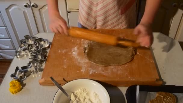 Las manos femeninas están enrollando una masa gira la masa Ponga una esposa de harina está haciendo galletas en una tableta de madera Moldes metálicos Galletas en forma de carnero en una bandeja para hornear — Vídeos de Stock