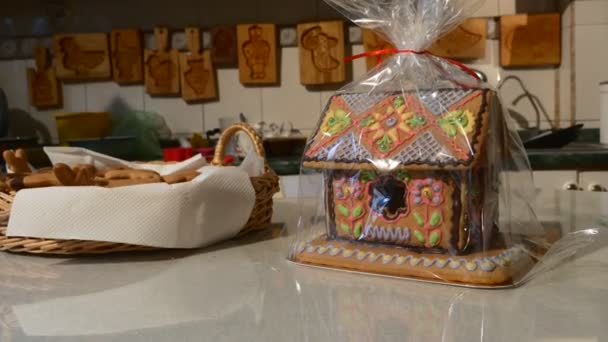 Haus-Kuchen in Polyethylen Backformen verpackt hängen an einer Wand Haus geformten Kuchen mit mastique engelförmigen Kekse in einem Korb Geschenke verziert — Stockvideo