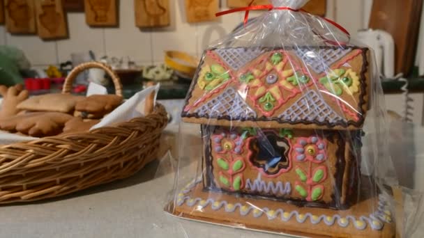 Huis-Cake verpakt in polyethyleen Angel vormige koekjes in een mand bakken mallen zijn opknoping op een muur huis Shaped Cake versierd met Mastique geschenken — Stockvideo