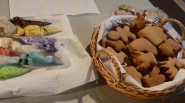 Bir tabloda bir peçete üzerinde renkli Mastique ile bir tablo Noel kurabiye bisküvi dekorasyon önce üzerinde bisküvi renkli Mastique sepeti ile paketleri