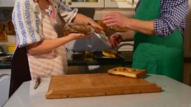 İnsanlar bir kahverengi hamur adam ambalaj kaldırır pasta koca yeşil önlük kadın eşi pembe önlük koyar bir ahşap fırın Ram şeklinde kalıp tabloya