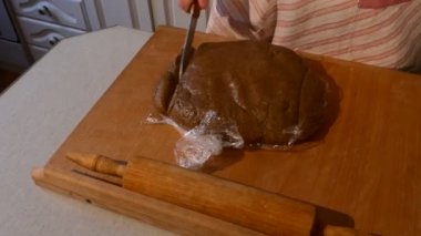 Eller bir parça, pasta hamur ahşap Tablet ahşap makara kadın eşi orta yaşlı iki yemek yoğurma onların mutfak kesiyorsun