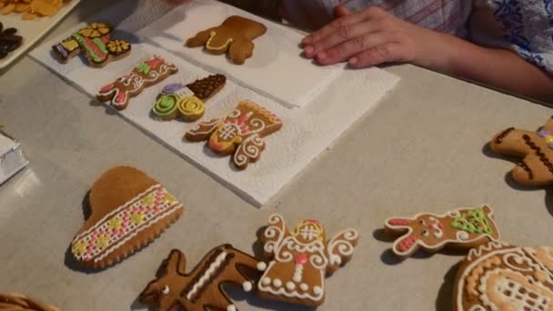 Hand är trycka vita Mastique Angel-Cookie kvinnan dekorera en jul kakor kex dekorerad med färgglada Mastique på en tabell tänkte Cookies — Stockvideo