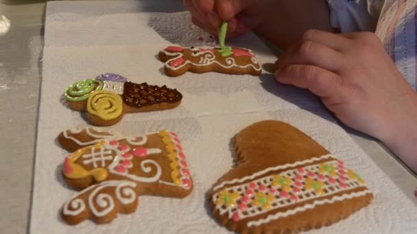 Mujer está poniendo un verde Mastique Conejo-Galletas Galletas de Navidad Galletas decoradas con colorida Mastique en una mesa delante de la mujer Botones de chocolate — Vídeo de stock