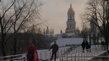 İki adam bir başka yaklaşım ve bir kucaklama arkadaşlar var bir araya geldi ayakta bir köprü kışlık Park ve yayalar Kievo Kulesi-Pecherskaya Lavra söz verin