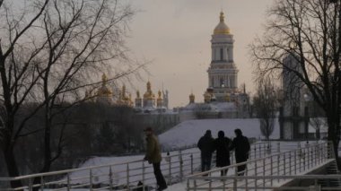 Bekleyen için elinde soğuk hava gizlemek O'nun O'nun silah atlama insanlar altında birisin yürüyüş Kiev Lavra of köprü altın kubbe tarafından kahverengi adamdır