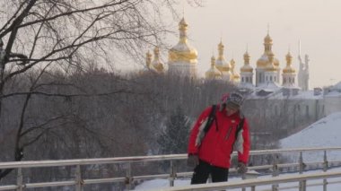 Biri ayakta eğildi köprü ayakta raylar için bir süre ve uzakta çalışan Backpacker kışlık Park altın kubbe Kievo-Pecherskaya Lavra bir ufukta içinde