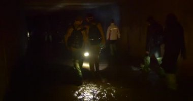 İki Erkek Backpackers Karanlık Mağara Kiev Yeraltı Nehirleri Gumboots Lambalar İnsanlar tarafından Yol Işık Turistler bir Grup Ayrı ayrı Su ile Yürüyüş