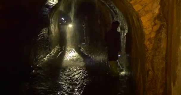 La gente está de pie frente a verter agua desde un techo en la cueva Luz de Excursión de Año Nuevo El Camino de Lamplight Turistas en el metro de Kiev — Vídeo de stock