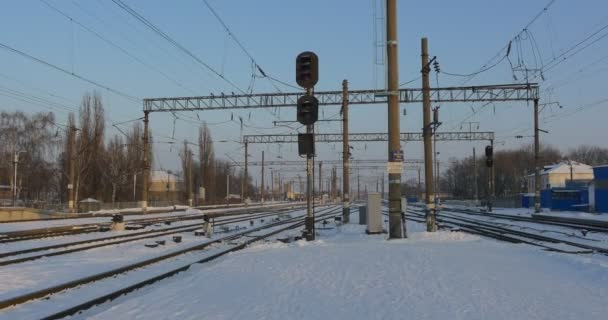 Panorama de ferrocarriles Estación de tren vacía de Konotop City en invierno Torres de alambre Edificios de una estación Nieve en tierra Puesta de sol Cielo despejado Ucrania — Vídeos de Stock