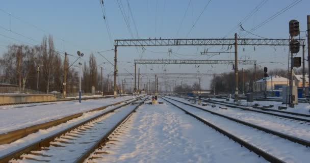 Panorama de ferrocarriles Estación de tren vacía de Konotop City en invierno Torres de alambre Edificios de una estación Nieve en tierra Puesta de sol Cielo despejado Ucrania — Vídeo de stock