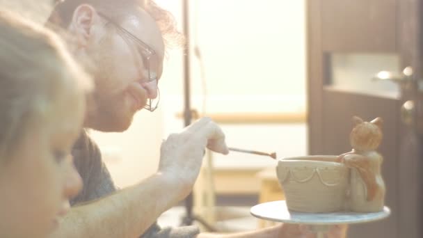 Middle Aged Man And Little Girl Man is Glazing Pot Attentively Sat Figurine is Holding a Pot People Are Making a Gifts From a Clay Learning a Pottery — Stock Video