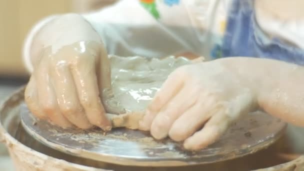 Les mains d'un enfant sculptent un pot Bords de poterie Roue Mains Gros plan Travailler mal à l'aise Enfant apprend une poterie Petite fille aux mains sales Gros plan — Video