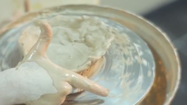 Маленькая девочка поворачивает гончарное колесо литья глиняной посуды гончарные колеса Грязные руки работы неловко обучения керамики в мастерской Маленькая блондинка — стоковое видео