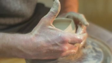 Adam bir Pot konuşurken kirli eller yakın kadar kalıp bir kil Pot çalışma çanak çömlek çarkı seramik Çalıştayı tutan bir ham toprak kap bir tekerlek kapalı alıyor