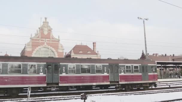 Czerwony pociągu Wagon zatrzymał się pasażerów sylwetki stoją na platformy czeka na pociąg elektryczny w The Railway Station zima śnieg pochmurny dzień — Wideo stockowe