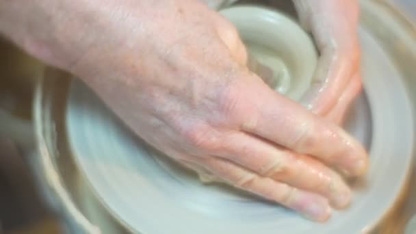 Manliga händer är gjutning en pott av tummen ansikte nära upp människan i glas är arbetar uppmärksamt Man gjutning en lera Pot nära upp arbetar på en Pottery Wheel — Stockvideo