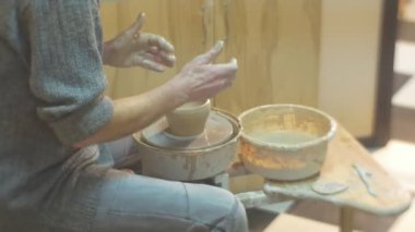 Adam bir çanak çömlek çarkı döküm bir kil Pot dikkatle ile yakından Spatula seyir Pot çalışan bir çanak çömlek çarkı seramik atölyesi, dönen