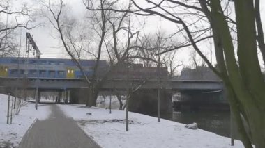 Tren Rides üzerinde Bridge Slow Motion yaya kaldırım altında bir köprü aracılığıyla a küçük River yapraksız ağaçlar Park kış Kiev The River tarafından