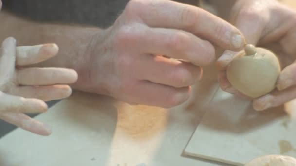 Mãos masculinas estão esculpindo uma cabeça para um garoto estatueta ajuda o homem a esculpir um homem do nariz está consertando os detalhes que as pessoas estão fazendo um presente Esculpir um Figurines — Vídeo de Stock