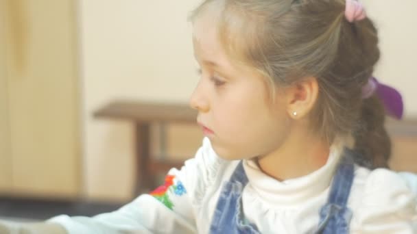 Niño está moldeando un círculo de arcilla esculpir un florero Niña rubia está trabajando en una rueda de cerámica concentradamente haciendo un regalo en taller de cerámica — Vídeo de stock