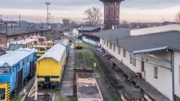 Uitzicht op het depot dak gebouwen oude wagons staande water toren timelapse roze bewolkt hemel avond zonsondergang Polen Opole Cityscape — Stockvideo