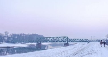 İnsanların çoğu yürüyüş boyunca bir nehir kar trenle hareketli demiryolu Köprüsü Hyperlapse Titelapse küçük evler çıplak dalları ağaçlar erken akşam kış tarafından bankadır