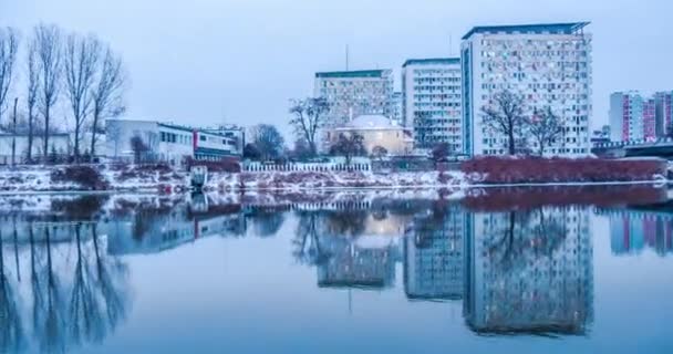 Este városkép Modern többszintes épületek Hyperlapse Titelapse sima víz csupasz ágak fák, híd a híd télen a hó panoráma autók — Stock videók