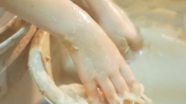 Çocuğun el yıkama su elleri ile bir kase içinde çocuk yakından bir seramik çalışmalarına bitti tekerlek seramik kurs bir hediye yapmak