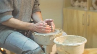 Orta yaşlı adam döner bir çanak çömlek tekerlek hızlı basarak bir kil O'nun yüz konsantre adam ile çalışırken zor atölye bir çömlek Craft öğreniyor