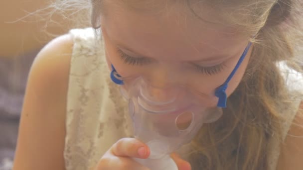 Dziewczyna usuwa The maska i Rubs jej twarz rozmowa siedzący z nebulizator maska na jej twarz Holding a zdejmowany telefon dziecko jest oddychanie przez inhalator — Wideo stockowe