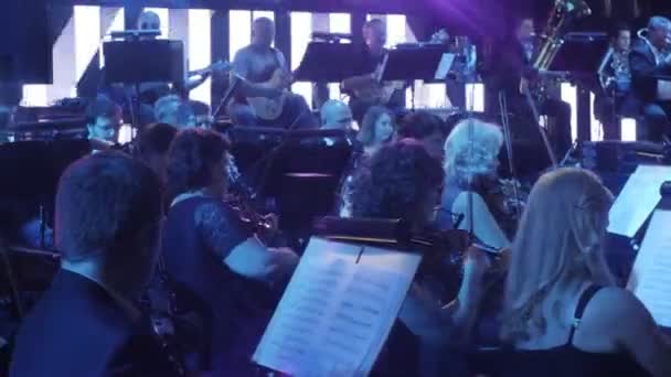 Gruppe von Geigern spielen Geigen Blaulicht in einem Saal die größten Hits von Rock-Symphonie ukrainischen Tournee-Konzert in Kiew Dirigent ist Nikola Lysenko — Stockvideo