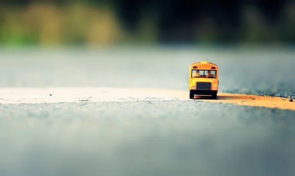 Sarı okul otobüsü oyuncak model ülke yolda.
