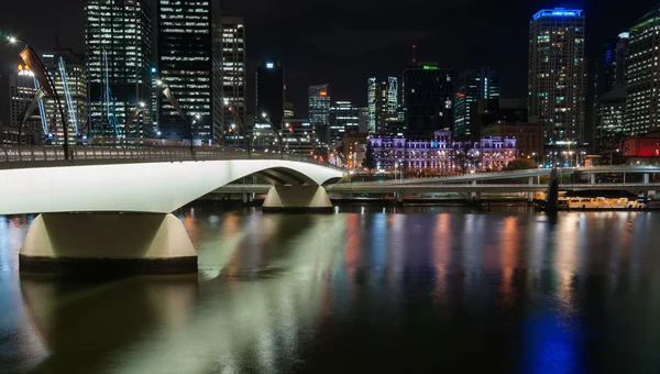 Brisbane, Australia - 27 kwietnia 2016; Oświetlona Brisbane Victoria Bridge przeciwko ciemności i miasto budynku — Zdjęcie stockowe