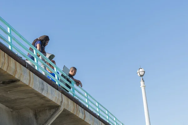 Femme et homme regardent du haut de la balustrade bleue de Manhattan Beach — Photo