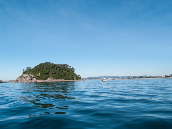 Mała wyspa off-shore całej niebieski ocean z niskiego punktu widzenia — Zdjęcie stockowe