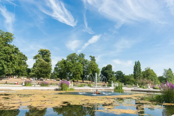 Dia de verão em Kensington Garden Londres Reino Unido pessoas tomando sol — Fotografia de Stock