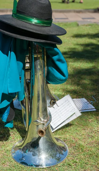 Brass musical instrument put on ground with hat when band takes