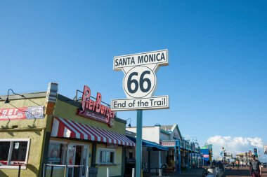 Los Angeles USA _ 6 Ekim 2015; Route 66 Santa Monica Trail Çıkmazı tabelası ve Pier Burger neonu mavi gökyüzünün altında
