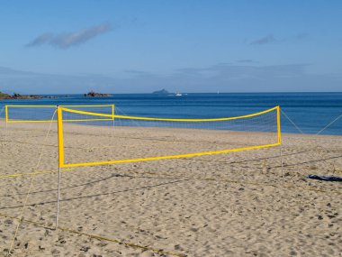 Sarı plaj voleybol ağları henüz hiç oyuncu olmadan Maunganui Dağı 'nın ana plajında kullanılmak üzere dikildi..