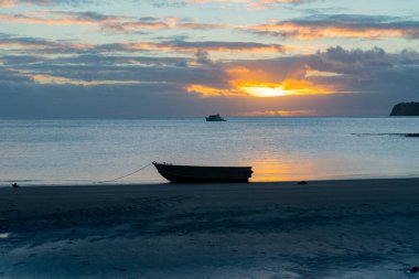 Mulberry Grove Sahili 'nde sular çekildiğinde Yeni Zelanda' daki Büyük Bariyer Adası 'nda bir sandal silueti..