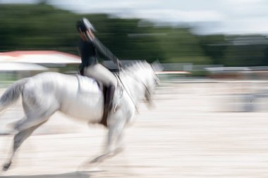 Soyut beyaz at ve binici hız ve eylemde bulanıklaştı.