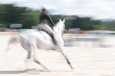 Soyut beyaz at ve binici hız ve eylemde bulanıklaştı.