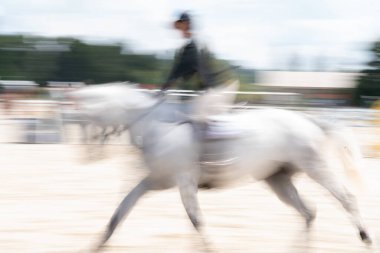 Soyut beyaz at ve binici hız ve eylemde bulanıklaştı.