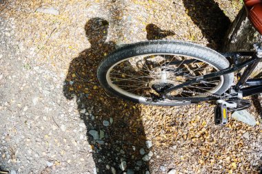 Bisikletlinin gölgesi, gölgeye odaklanmış bisikletin arka tekeriyle.