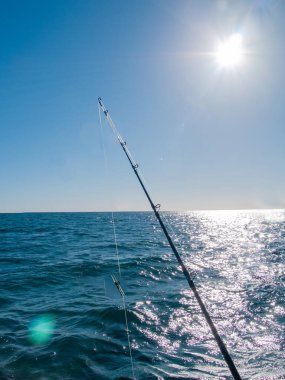 Güneş ufuktan ve mavi denizden yükselirken gün boyu balık tutmak