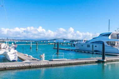 Auckland Yeni Zelanda - 17 Haziran 2021; Auckland Habour köprüsü için liman iskeleleri ve lüks tekneler Stanley Körfezi 'nden ön plan oluşturur..